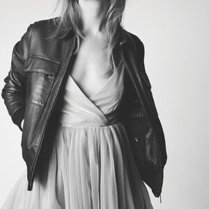 standing woman with hands in jacket's pockets