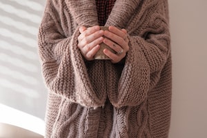 person in brown knit sweater