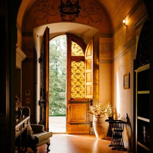 A hallway with a large wooden door leading to another room